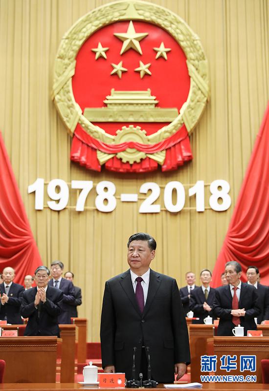说明: 12月18日,庆祝改革开放40周年大会在北京人民大会堂隆重举行。中共中央总书记、国家主席、中央军委主席习近平在大会上发表重要讲话。这是习近平在主席台向全场致意。 新华社记者 鞠鹏 摄